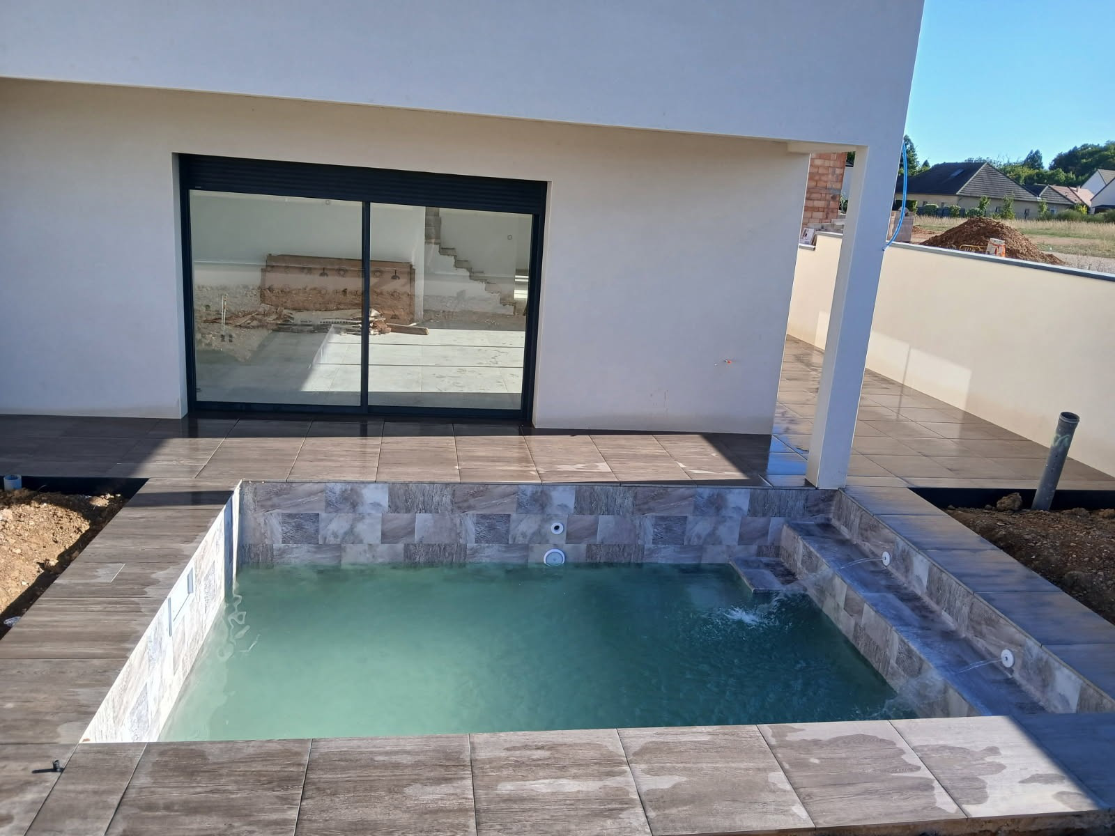 Installation des équipements, filtration, tuyauterie, pompe et finitions des aménagements autour de la piscine, margelle, dallage